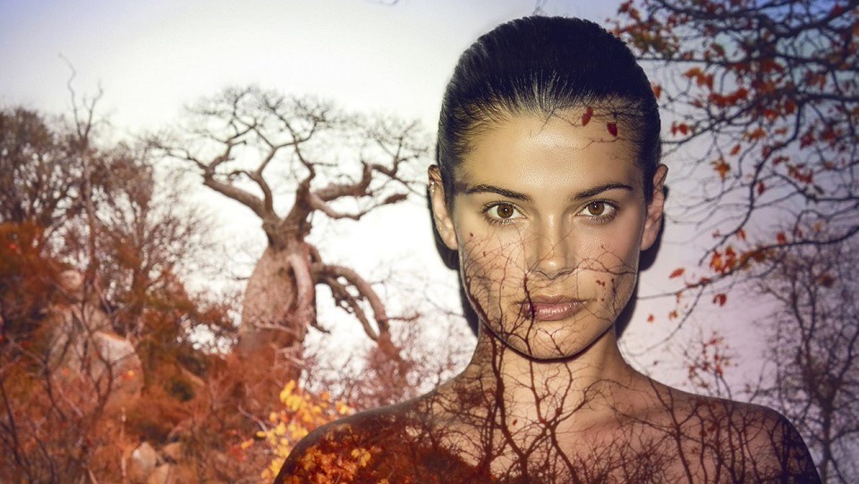 Naisen päälle heijastettu projektorikuva jossa metsää.
